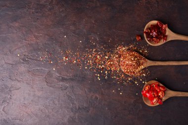 Kurutulmuş kırmızı biber ya da ahşap bir kaşıkta kırmızı biber fotokopi alanı olan koyu bir arka plana yerleştirilir.