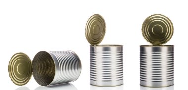 Beyaz arka planda açık kapaklı gümüş metal yemek kutuları.