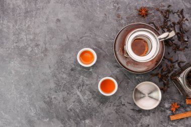 Top view of hot tea in a jug and in a teacup placed on a vintage table.