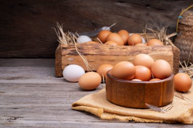 Chicken eggs in a basket placed on a wooden table, rural farm
