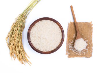Jasmine or white rice in a wooden bowl with ears of rice isolated on a white background, top view