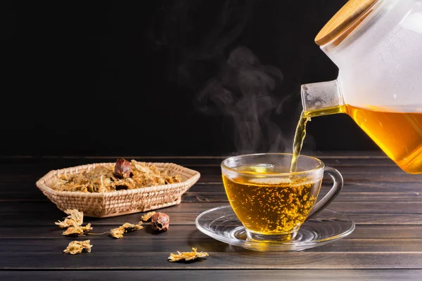 Chrysanthemum tea and Chrysanthemum flowers in a basket on a wood background. Healthy beverage for a drink. Herbs and medical concepts.