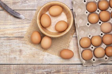 Tahta bir kasedeki taze tavuk yumurtaları kırsal kesimden taze organik yumurtalar. Odaya ahşap bir masa koyun.