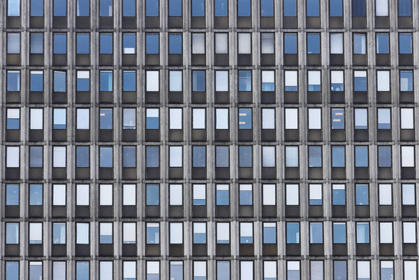 Full frame view of an office building facade with a pattern of windows.