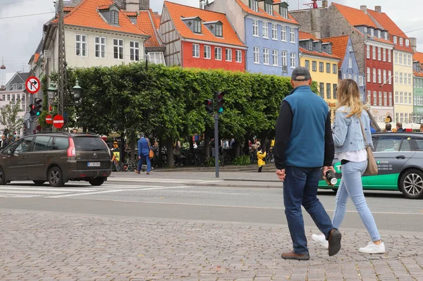 Kopenhag, Danimarka - 14 Haziran 2020: İnsanlar Kongens Nytorv meydanında Nyhavn 'daki binalarla yürüyorlar.