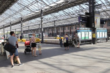 Helsinki, Finland - August 20, 2022: View of the platform area with waiting passengers at the Helsinki central railroad station.