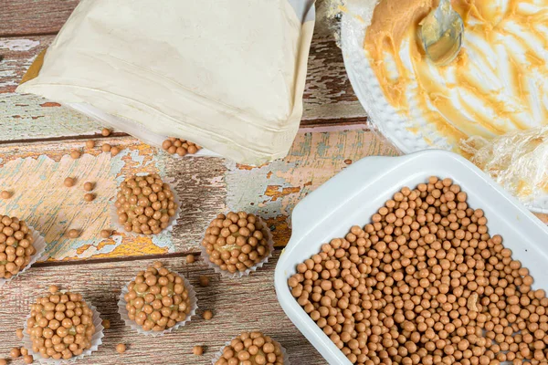 Dulce de leche brigadiers. Küçük toplar halinde tuzlanmış karamel ve ambalajlarının yanında..