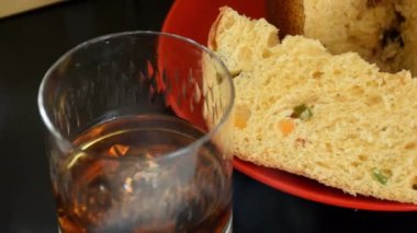 Panettone diliminin yakın plan görüntüsü dumanın altında, viski bardağının yanında ve gelo _ side izleme _ zoom out.