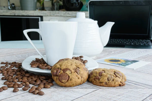 초콜릿은 지원하는 쿠키를 떨어뜨린다 원두에 해바라기 사진이 둘러쌓여 보이는 노트북입니다 — 스톡 사진