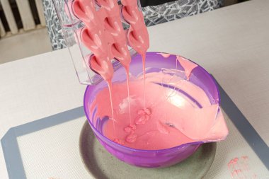 Çilekli ganache ile doldurulmuş polikarbonat tavasını dolduran şekerci..