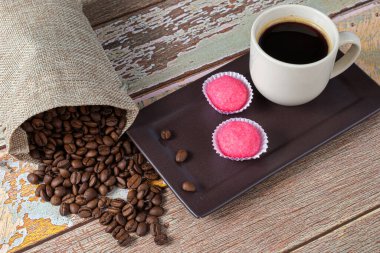 Brigadeiros bicho de pe 'nin yanında kahve çekirdeği ve bir fincan kahve..