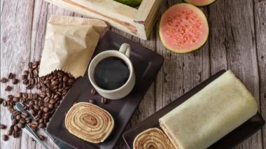 Kahverengi tabakta, çatal bıçak, fasulye ve kahve ile çevrili bir Bolo de rolo.).