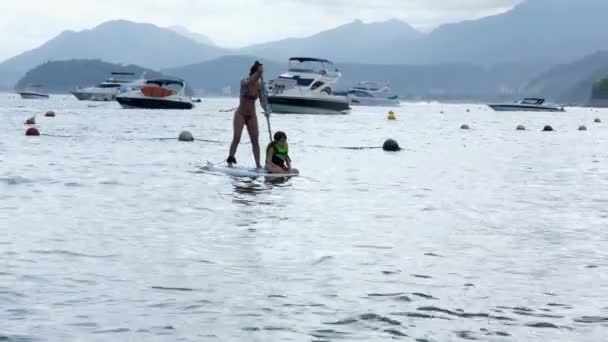 Річна Бразилька Спокійно Плаває Разом Своїм Сином Під Час Веслування — стокове відео