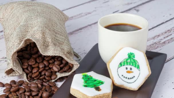 Großaufnahme Von Butterschnäbeln Mit Schneemannzeichnung Neben Tasse Und Kaffeebohnen — Stockvideo