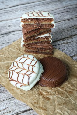 Geleneksel Brezilya ballı kekleri ve beyaz çikolatalı kekler. Dulce de leche ile doldurulmuş. Arka planda, yarıya bölünmüş kesikler ve istiflenmiş _ dikey fotoğraf.