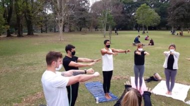 Sao Paulo, Sao Paulo / Brezilya, 4 Temmuz 2021. Yoga pratisyenleri kollarını açıp kapayarak ayakta duruyorlar..