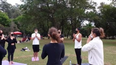 Sao Paulo, Sao Paulo / Brezilya, Temmuz 04, 2021. Yoga pratisyenlerini çevreleyen kamera halka açık bir parkta selam veriyor..