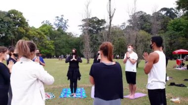 Sao Paulo, Sao Paulo / Brezilya, Temmuz 04, 2021. Halk parkında yoga selamı veren, gözleri kapalı pratisyenler..