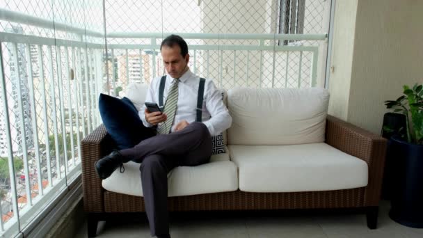 Hombre Ropa Formal Tirantes Sentado Sofá Bailando Con Smartphone Auriculares — Vídeos de Stock