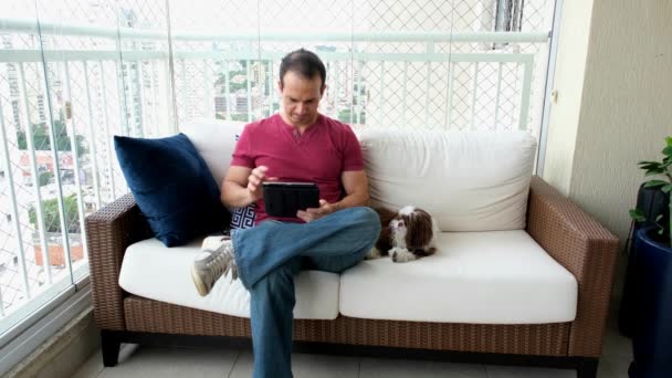 Years Old Male Sitting White Sofa Working Tablet Next His — стоковое видео