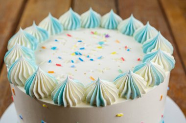 Yuvarlak vanilyalı kekin tepesine zefir şeklinde tereyağlı krema ile yakın plan..