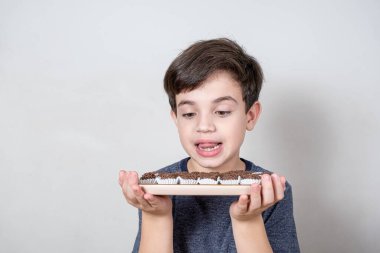 9 yaşında, elinde Brezilya şekerleri olan bir tepsiye bakıyor..