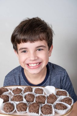 9 yaşında bir çocuk elinde bir tepsi dolusu Brezilya şekerlemesi ve kocaman bir gülümsemeyle..