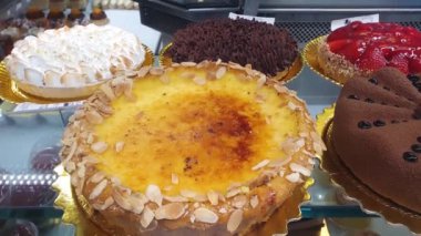 Brulee pie topped with slices of toasted almonds in a Brazilian bakery showcase.