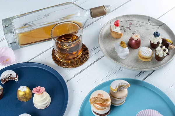 Walnut cameo surrounded by fancy wedding candies, glass and bottle of whiskey.