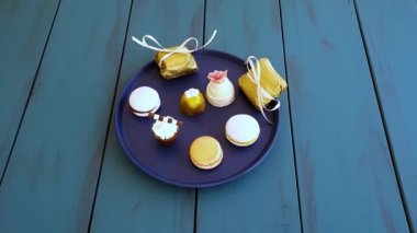 Man picking up a macaron, next to other fancy sweets from weddings_top view.