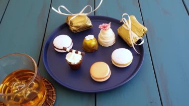 Man taking a macaron next to other sophisticated Brazilian wedding sweets.