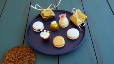 Man leaving a glass of whiskey and taking a macaron, next to other sophisticated Brazilian wedding sweets.