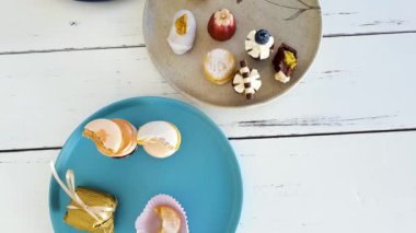 Sophisticated sweets on plates, top view. Macarron, walnut cameo, chocolate truffle and wedding sweet treat.