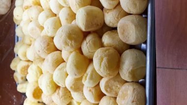 Closeup of Brazilian cheese puffs smoking in the showcase of a Brazilian bakery_vertical.