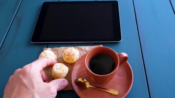Man Picking Brazilian Cheese Rolls Next Cup Coffee Tablet Blue — Stok video