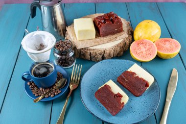 Peynirle çevrili guava tatlısı ve mavi masada kahve çekirdekleri.