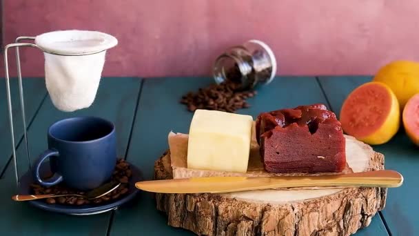 木の板の上にカードチーズとグアバ甘い 横にはコーヒーを作る男がいて — ストック動画