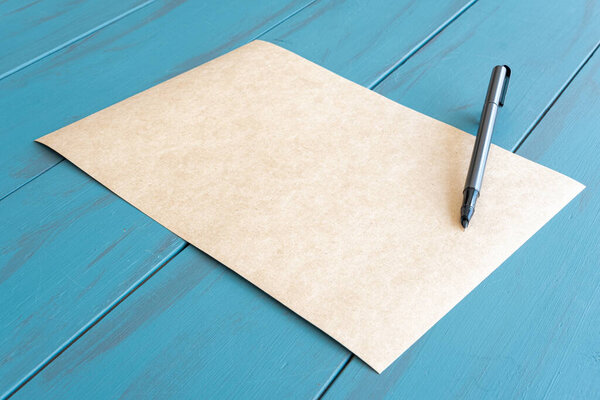 Gray fountain pen on an empty brown paper_blue table.