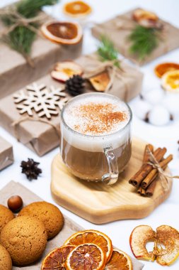 Tarçınlı Latte Coffee ve Noel hediyeleri, kurumuş meyveler, kozalaklar ve köknar dalları. Sıcak kış tatili geçmişi. 