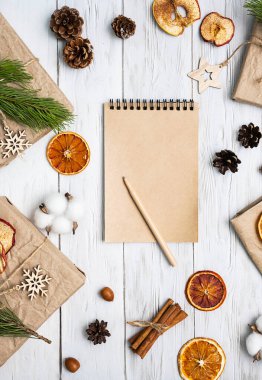 Boş spiral defter ve hediye kutuları el işi kağıtlar, dekore edilmiş kuru meyveler, kozalaklar, köknar dalları. Sıfır, Noel kompozisyonu. Moda kış tatili markalaşması..
