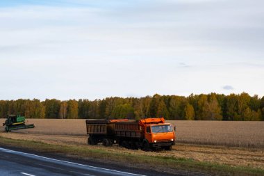 Tarım endüstrisi konsepti, tarım tarlasında çalışan tarım makineleri ve kamyonlar..