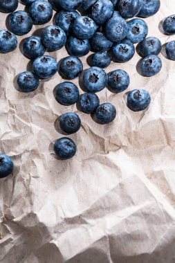 Kahverengi el işi kağıdının üzerinde organik, olgun yaban mersini, yakın plan, uzayı kopyala. Sağlıklı atıştırmalıklar, yemek geçmişi.