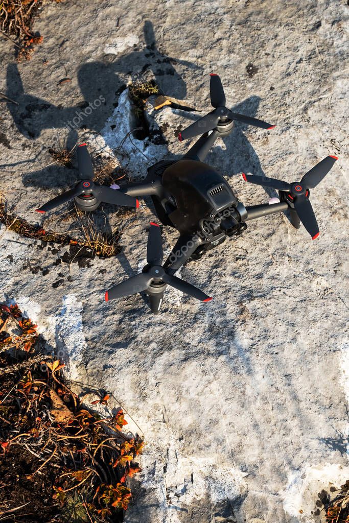 Kemerovo, Russia - 17 October 2021: DJI's first groundbreaking FPV drone staying on stone surface ready to fly, outdoors, sunny fall day.