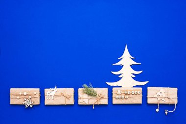 Tahta Noel ağacı, hediye kutuları, düz yataklar, fotokopi alanı. Kış tatili kompozisyonu, modaya uygun minimum stil.