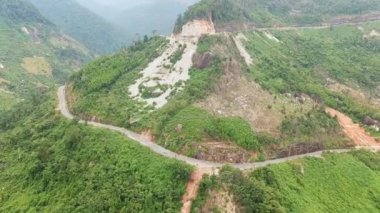 Tropikal dağ manzaralı çakıllı yolda uçan bir dron görüntüsü. Yeşil orman yolunun havadan görünüşü, tatil, macera.