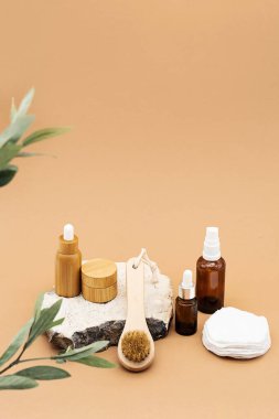 Boş kehribar cam ve bambu esaslı yağ şişeleri, pipette, cam sprey şişesi ve bambu kavanozu doğal taş kürsüde. Organik kaplıca kozmetik güzellik ürünü..