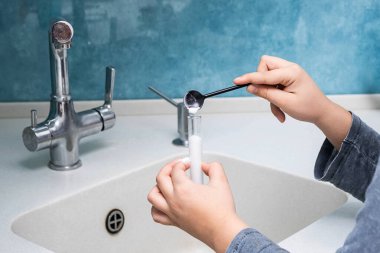 Mutfakta sirke ve kabartma tozuyla deneyler yapan tanınmayan bir çocuğun görüntüsü. Fen eğitimi, evde oynamak.. 