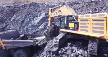 Belovo, Rusya - Mayıs 2019. Sarı maden kazıcısının drone görüntüsü kömürü açık kömür madencilik alanındaki büyük çöp kamyonuna yüklüyor. Taş ocağındaki madencilik işleminin hava görüntüleri.. 