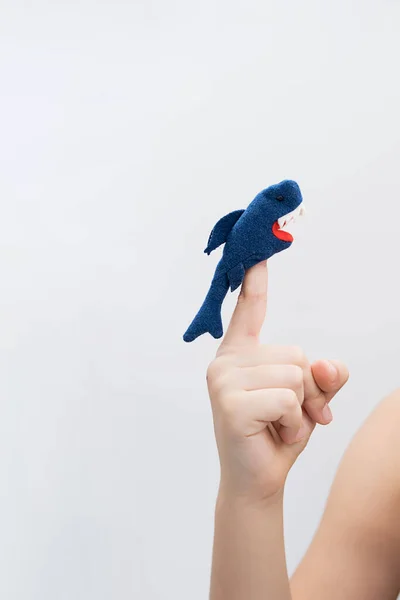 少年は動物の指のおもちゃの図を再生します 子供の手 人形劇の指に置かれたサメの姿 — ストック写真