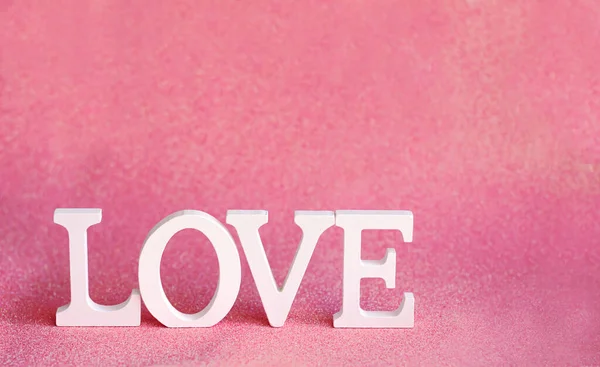 Love という言葉はピンクの輝きを背景に白い文字で作られています バレンタインデー 柔らかい本 — ストック写真